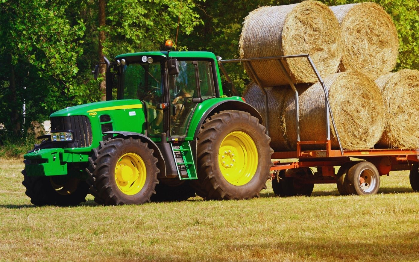 traktor z przyczepą i bloki siana